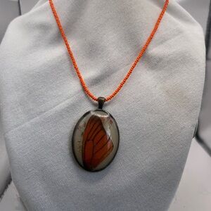 Oval Butterfly wing with flowers enclosed in a glass Pendant & orange seed pearl